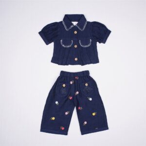 Justtots A chic two-piece navy blue textured cotton set featuring a stitch-detailed button-down shirt and matching floral embroidered trousers with tassel pockets.